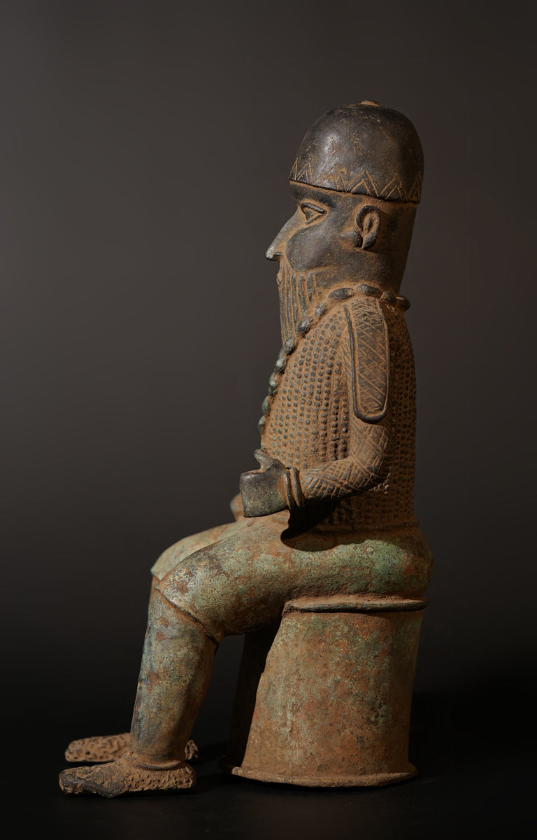 A Bronze in the style of Benin of a sitting Portuguese soldier