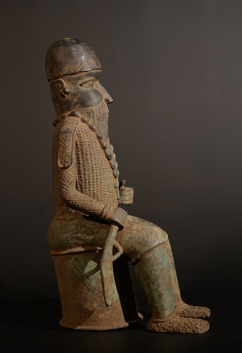 A Bronze in the style of Benin of a sitting Portuguese soldier