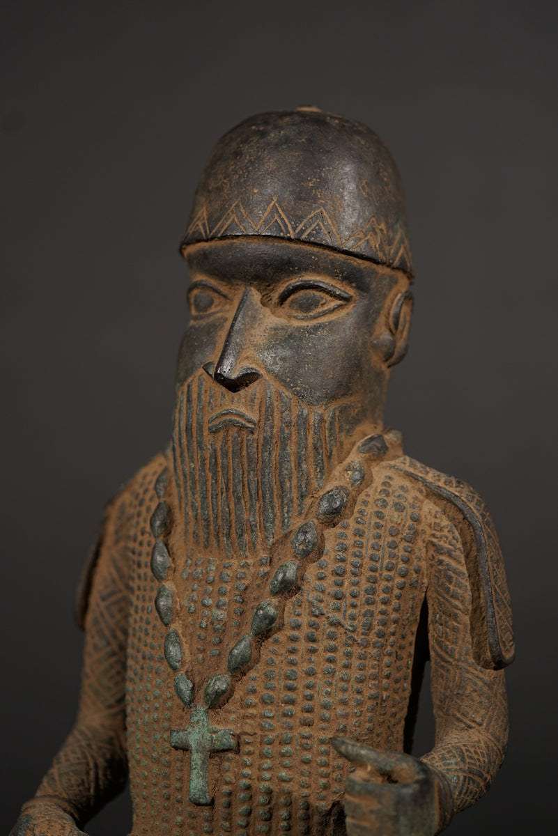 A Bronze in the style of Benin of a sitting Portuguese soldier