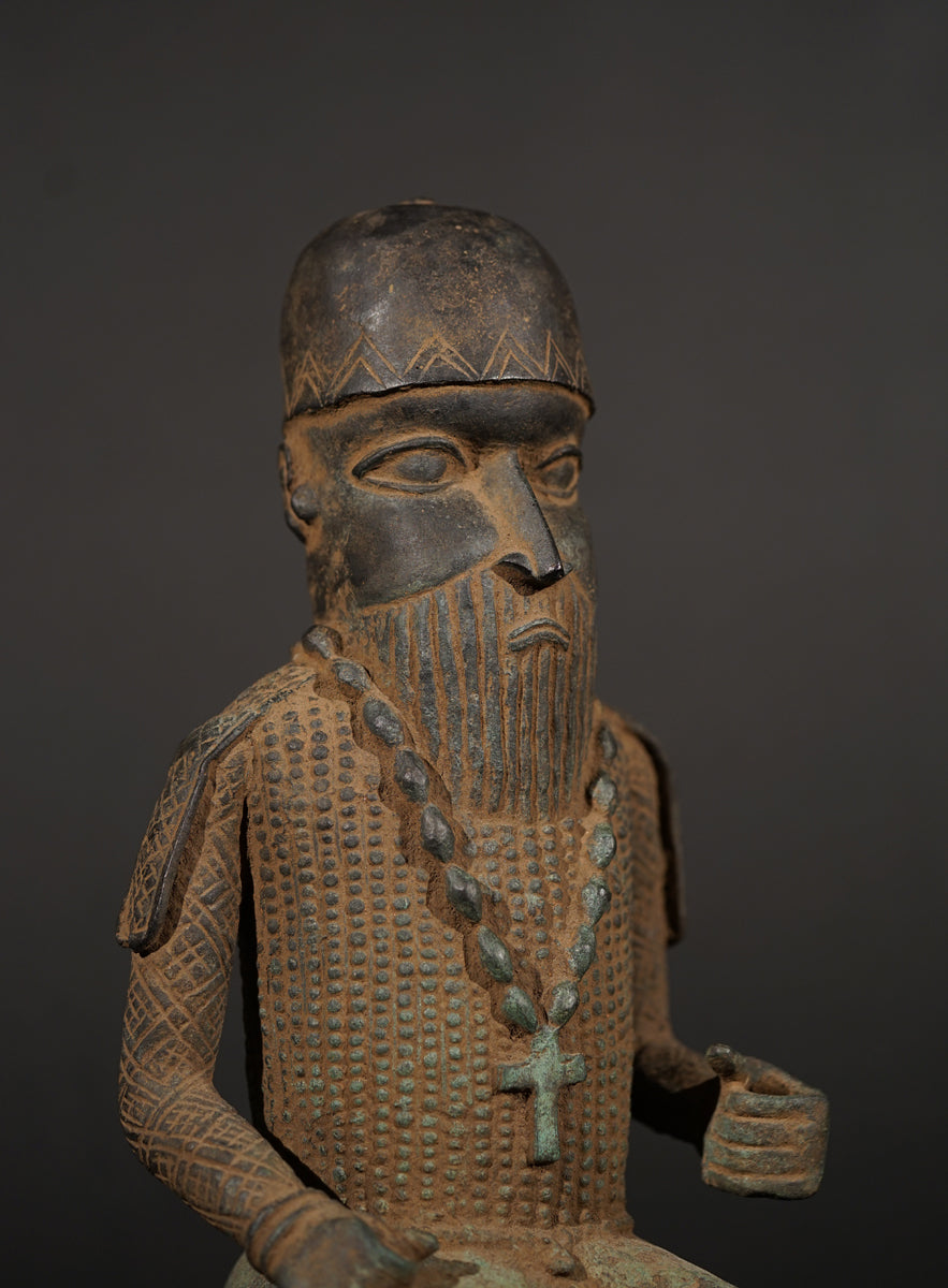 A Bronze in the style of Benin of a sitting Portuguese soldier