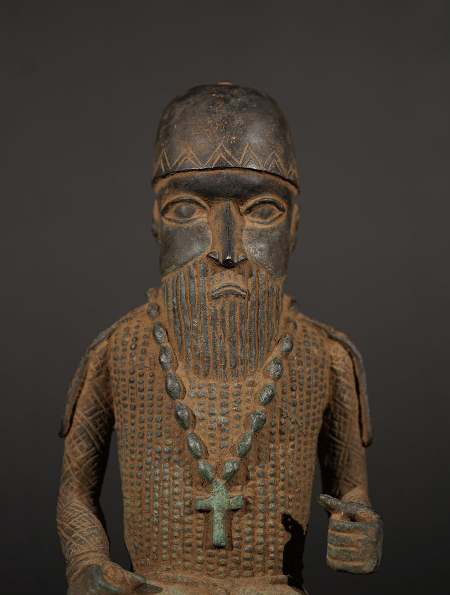 A Bronze in the style of Benin of a sitting Portuguese soldier