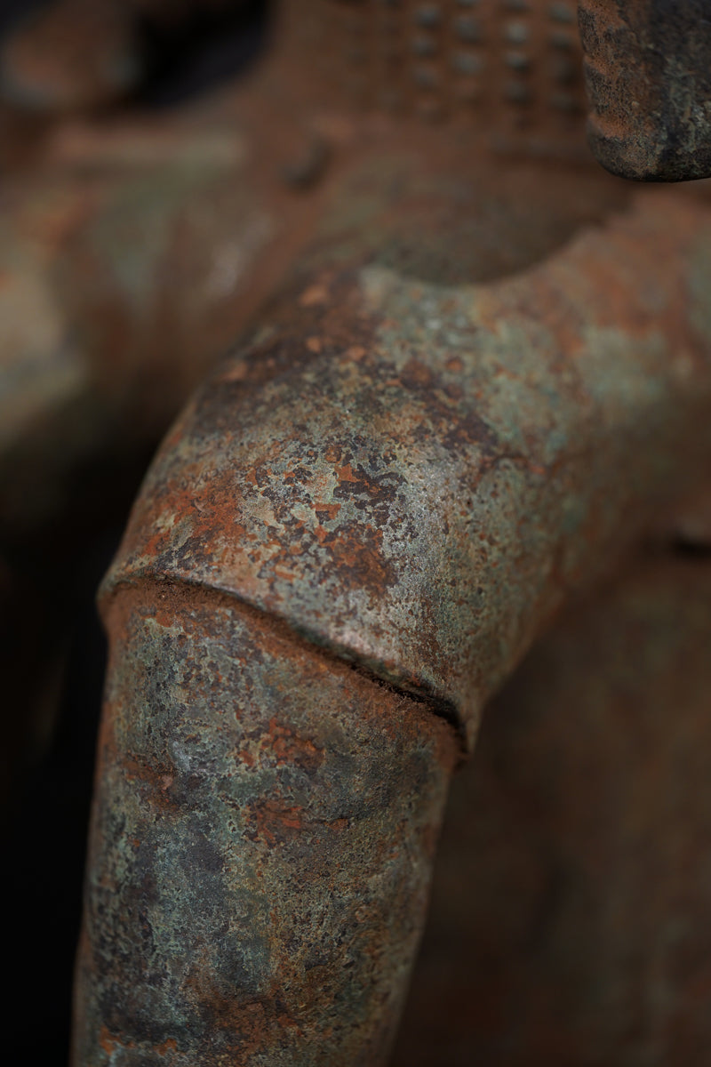 A Bronze in the style of Benin of a sitting Portuguese soldier