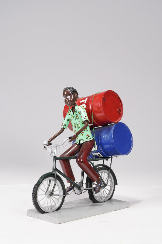 A young man on a bike trasporting petroleum barrels