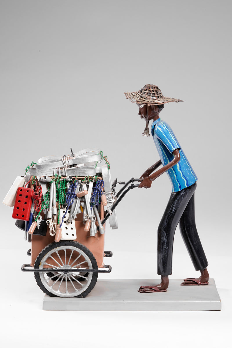 A salesman pushing his goods from the area of a hardware store on a cart