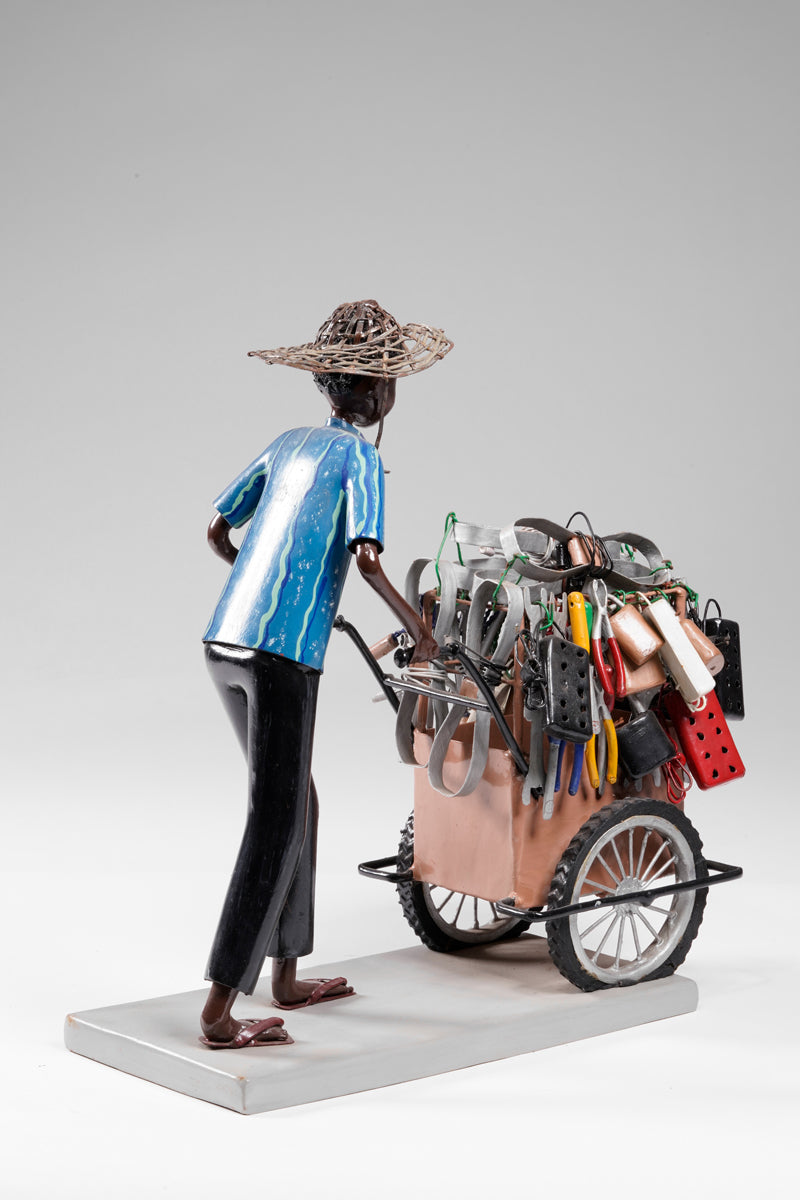 A salesman pushing his goods from the area of a hardware store on a cart