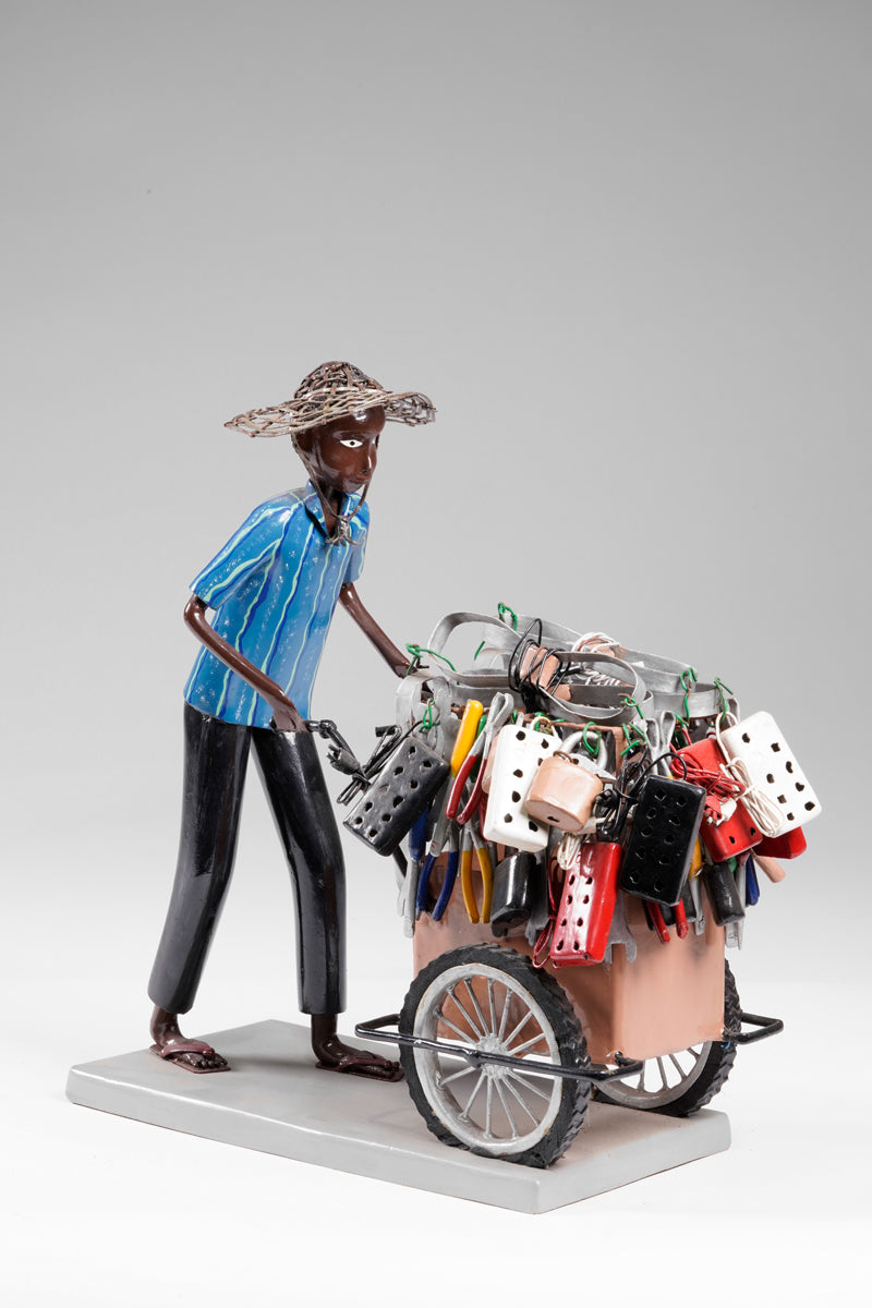 A salesman pushing his goods from the area of a hardware store on a cart
