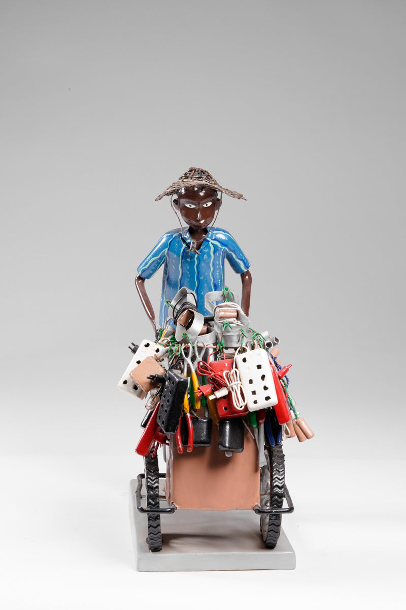A salesman pushing his goods from the area of a hardware store on a cart