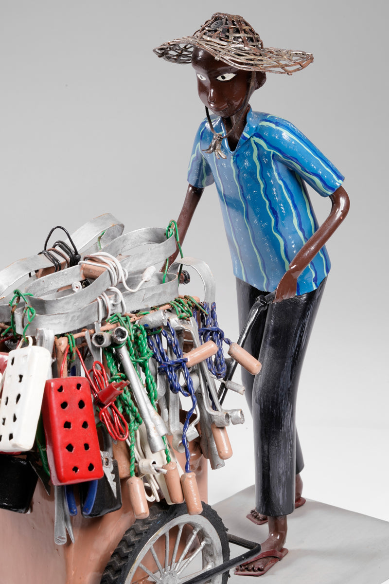 A salesman pushing his goods from the area of a hardware store on a cart