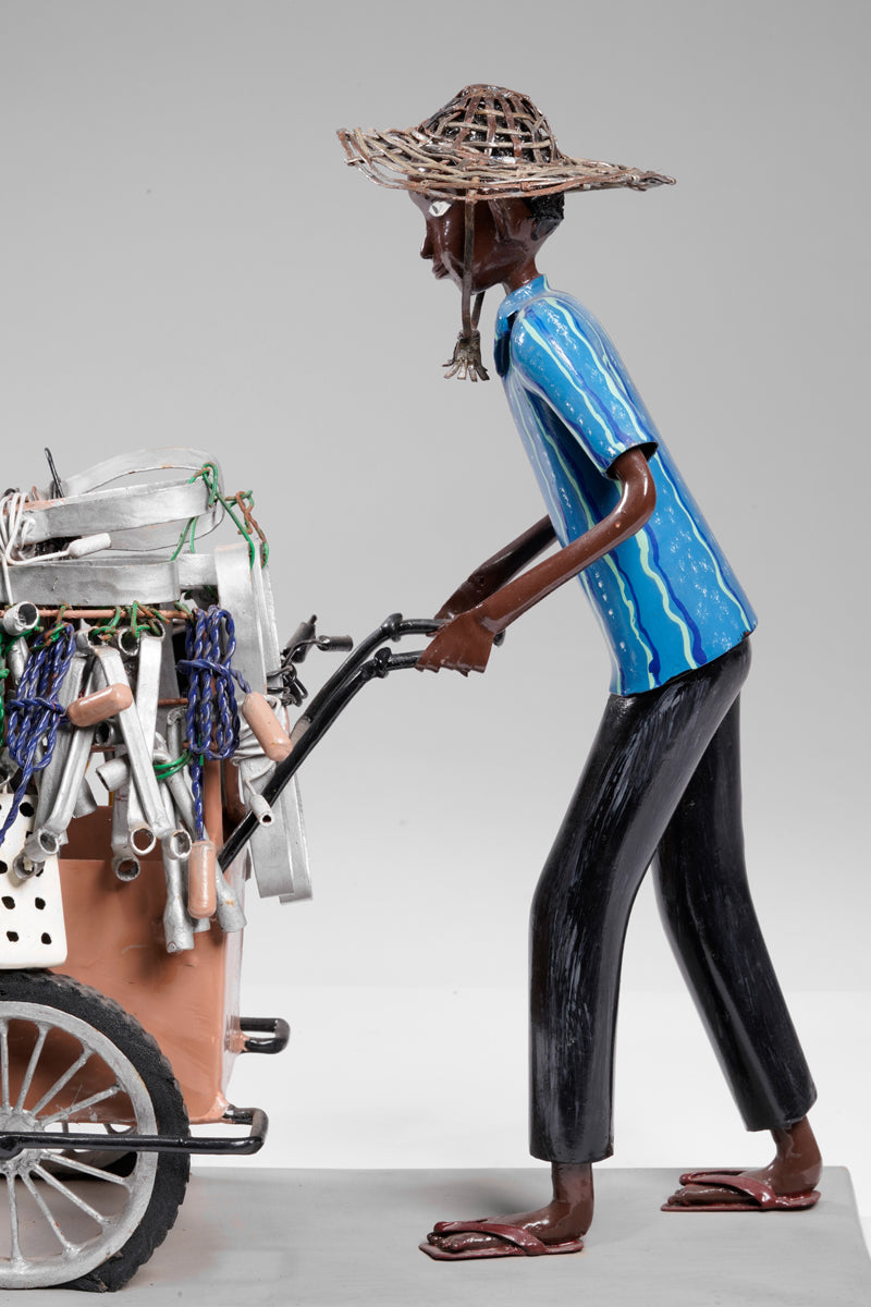 A salesman pushing his goods from the area of a hardware store on a cart