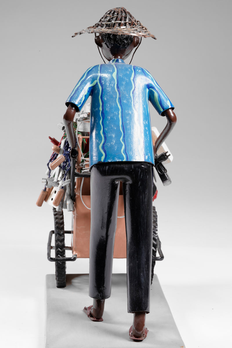 A salesman pushing his goods from the area of a hardware store on a cart