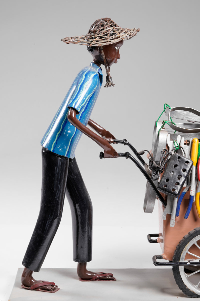 A salesman pushing his goods from the area of a hardware store on a cart