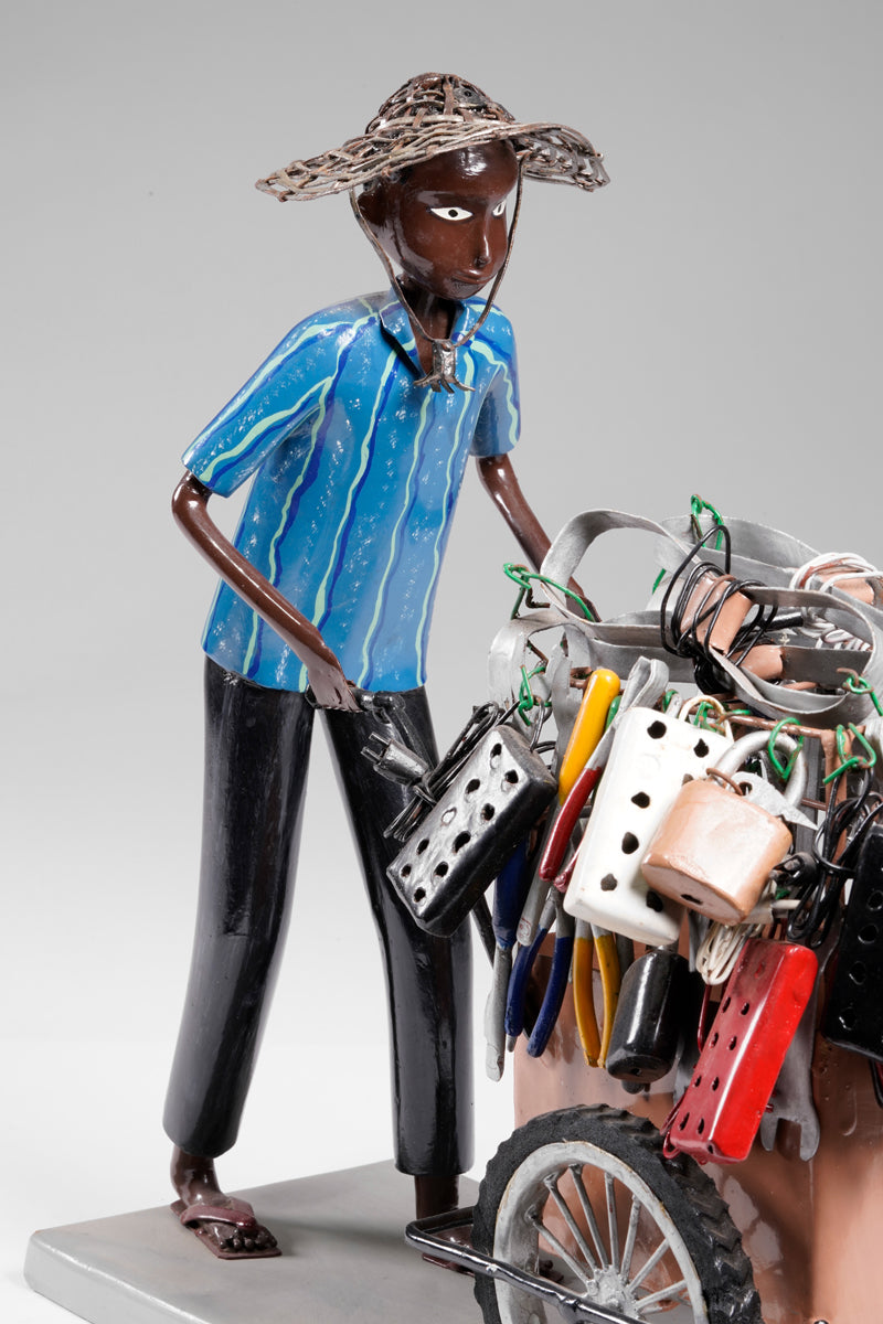 A salesman pushing his goods from the area of a hardware store on a cart